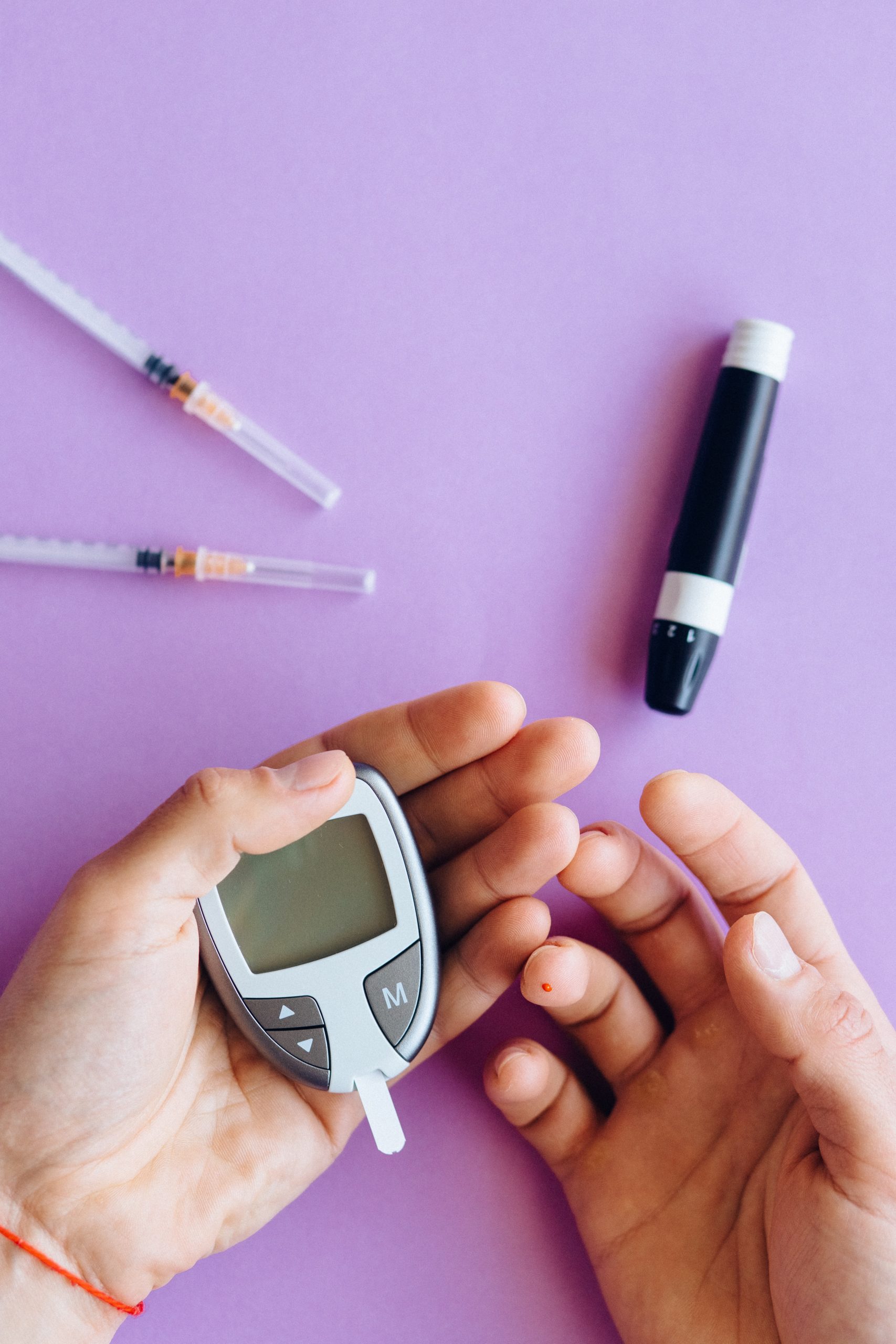 This picture depicts an individual using a glucose meter to administer insulin which typically can be covered by certain Medicare Advantage Special Needs Plans